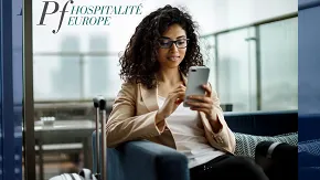 Photographie d'une jeune femme lisant sur son smartphone, pour illustrer le lancement de la SCPI PF Hospitalité Europe gérée par PERIAL Asset Managemt