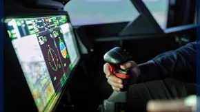 Pilote tenant le manche d'un avion dans un cockpit face à un écran de cartographie aérienne