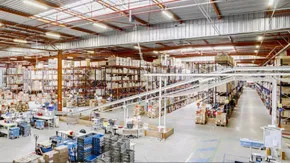 Photographie d'un grand entrepôt de logistique vu de l'intérieur pour illustrer son acquisition par Alderan pour le compte d'un OPPCI